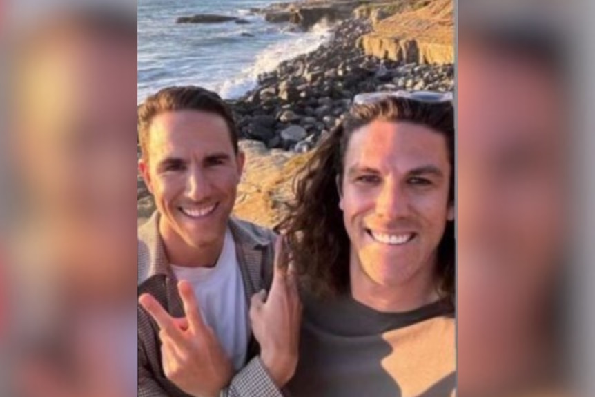 Jake and Callum Robinson smiling on a beach