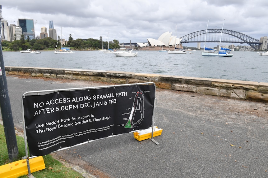 a sign along a wall on sydney foreshore warning people to stay away