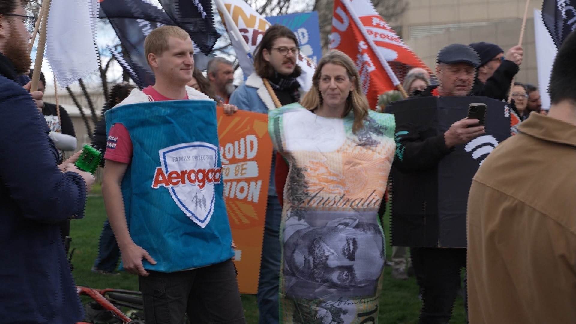 People dressed up as Aerogard, a plastic bank note, and wi-fi at a rally
