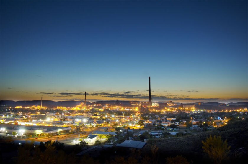 A long-range view of a city lit up with lights at dusk.