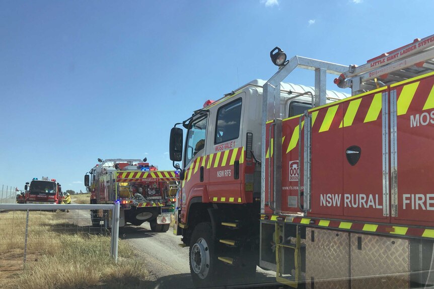 A fire truck parked next to a paddock.