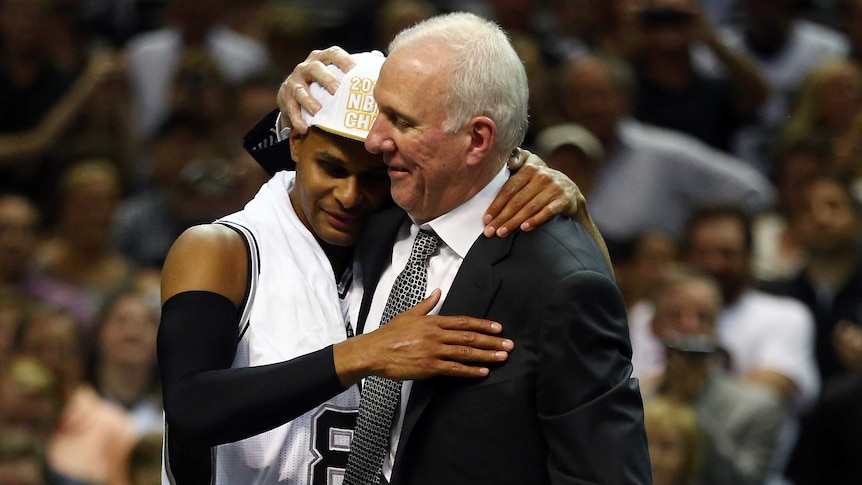 Patty Mills congratulated by Gregg Popovich