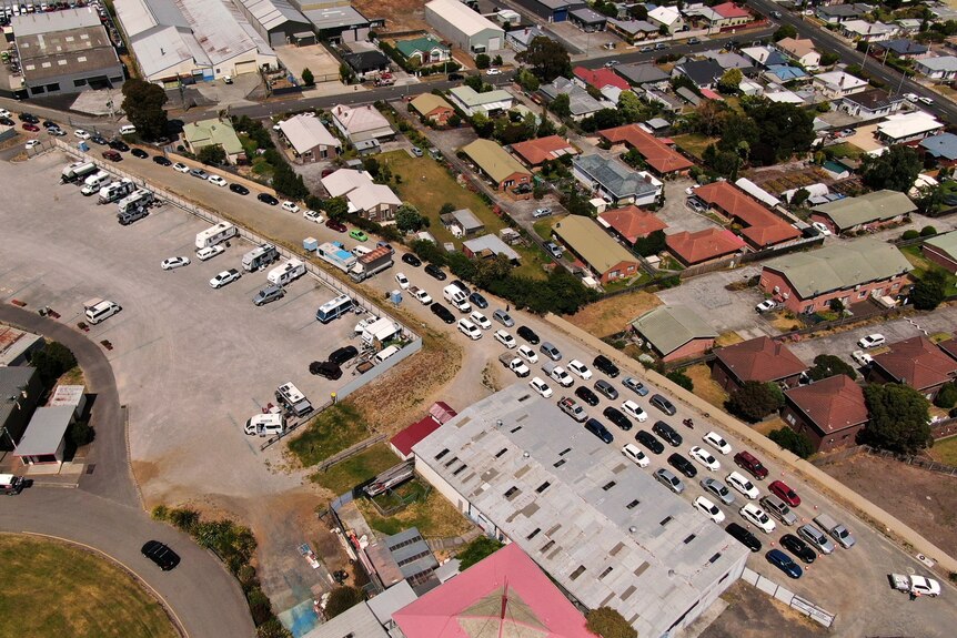 A birds eye view of cars lining up at a showground waiting for a COVID-19 test.
