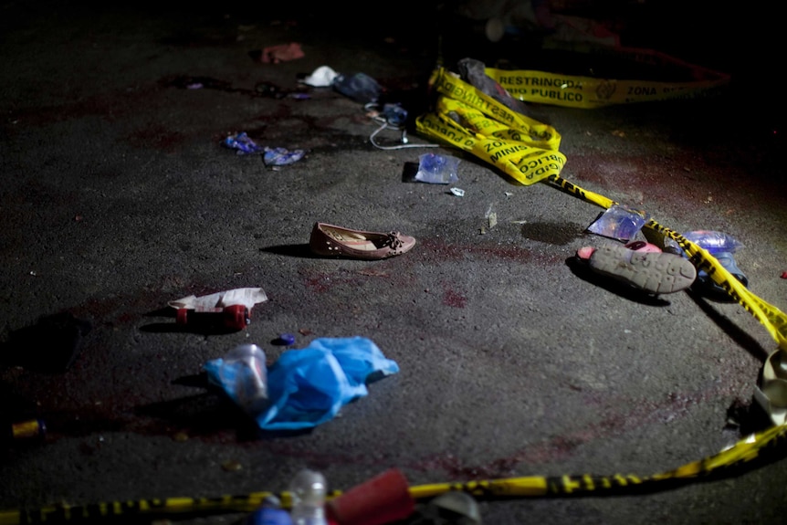 A road with blood spots, shoes and random items from victims, along with police tape