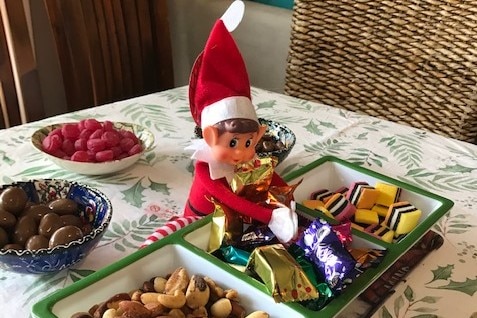 A toy with its hands in the chocolate dish.