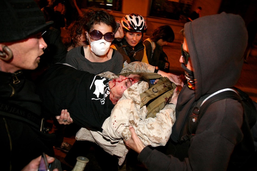 The Occupy Oakland protesters carry away Scott Olsen after he was hit by a tear gas canister