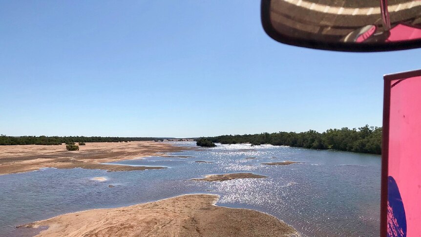 A shot of the degrey river out the window of a road train travelling across a bridge