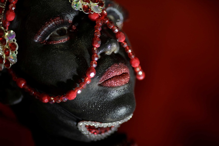 A reveller from Salgueiro performs in black face makeup.