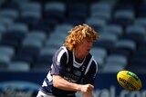 Cats midfielder Cameron Ling handballs during a Geelong AFL training session
