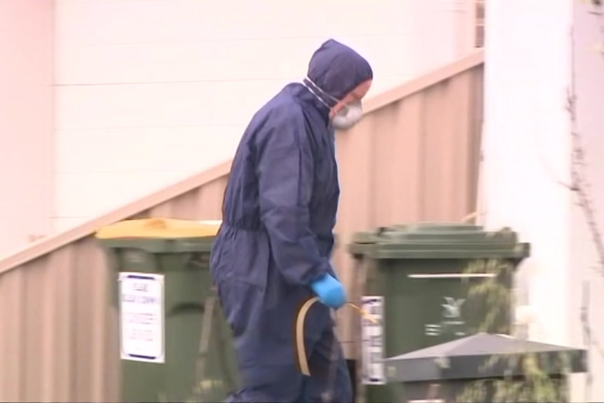 A forensic officer enters a house