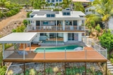 A large, luxury home on a hill with a pool