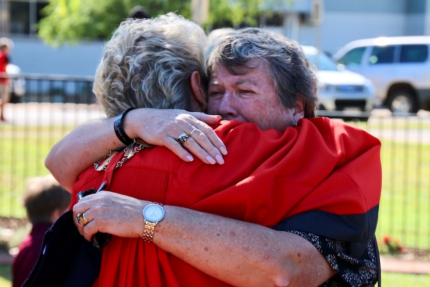 An emotional Pam Palmer is hugged by Katherine's Mayor, Faye Miller.