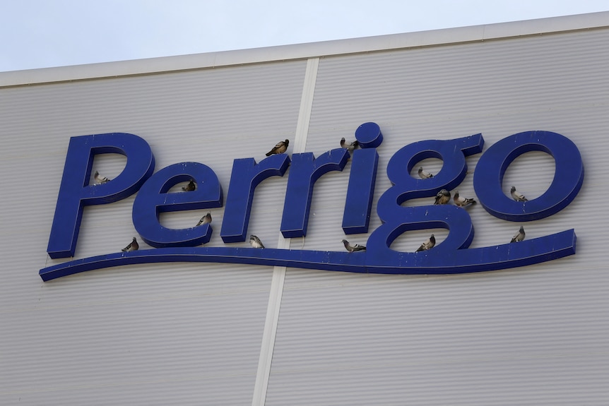 De grosses lettres en bleu sur le côté d'un bâtiment orthographe nom de l'entreprise Perrigo