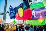 The Australian, Aboriginal and Torres Strait Islander flags are carried by fans on the Sydney Harbour Bridge.
