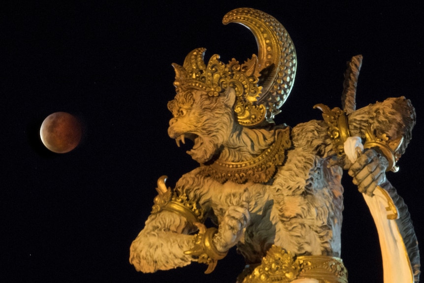 Moon next to a statue over Bali