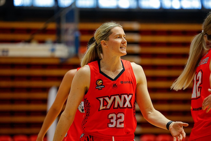 WNBL player Sami Whitcomb walks among teammates at basketball training with the Perth Lynx.