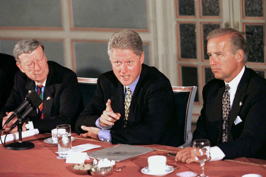 Joe Biden listens to Bill Clinton speak