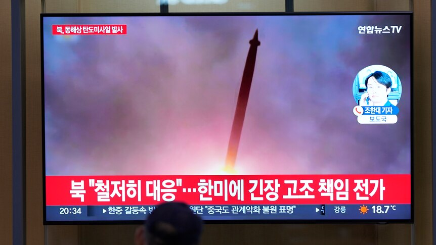 A TV screen at Seoul Railways Station shows a news program showing file footage of a North Korean missile launch