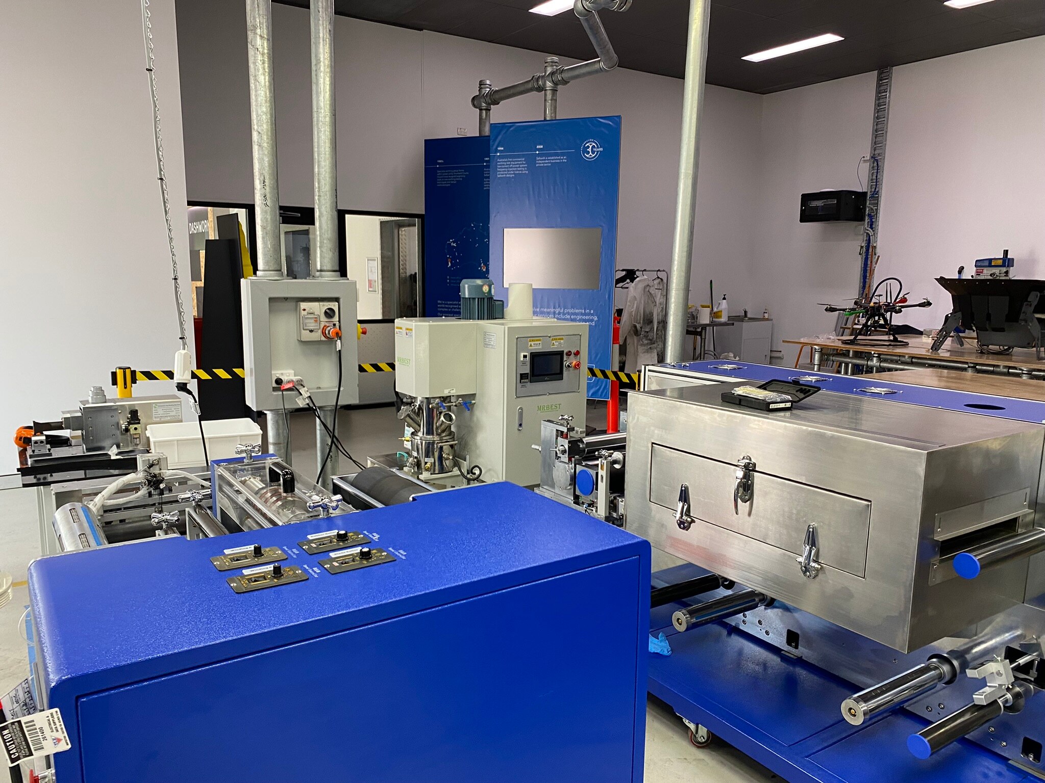 Th inside of a laboratory with machines set up on a blue bench.