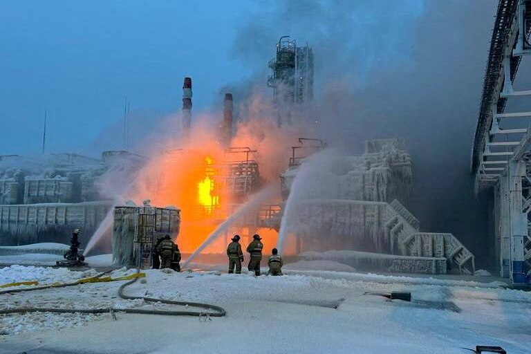 Firefighters hose down a fire in the middle of a snow covered terminal 
