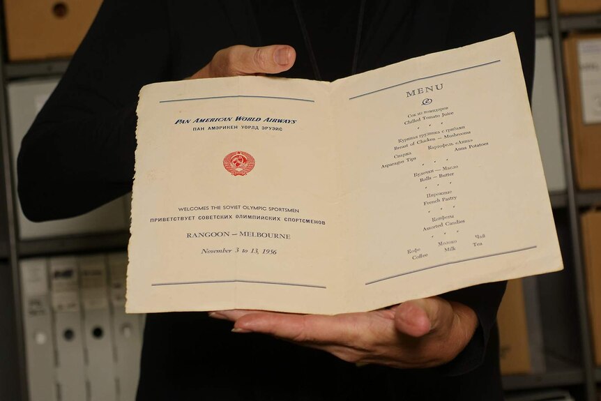 A photo of a 1956 airline menu being displayed for the camera.