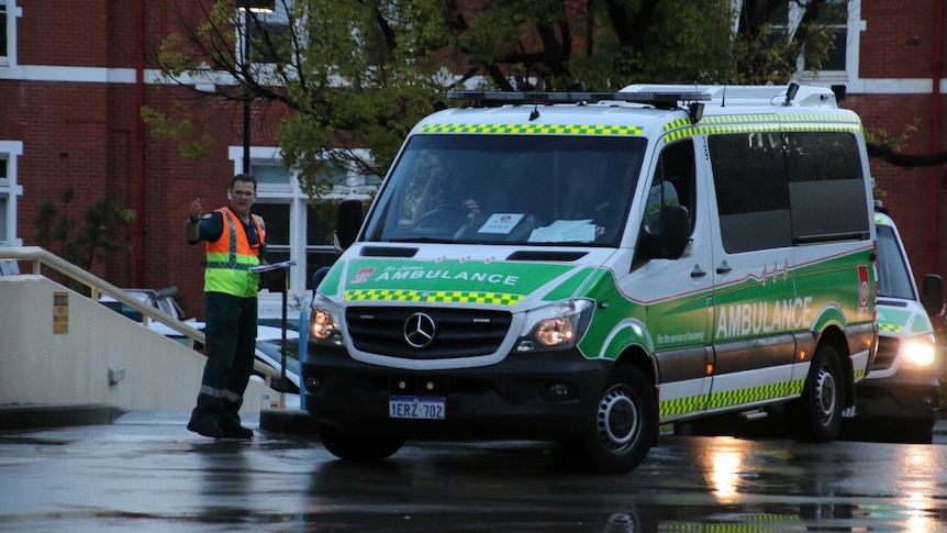 A St John Ambulance leaves Princess Margaret Hospital, directed by a paramedic in a hi-vis vest