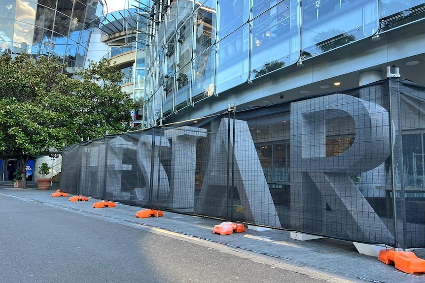 Giant letters spelling out 'The Star' covered by a temporary fence.