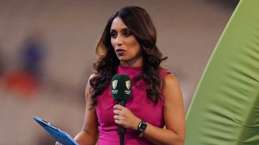 Isa Guha speaks into a microphone during cricket coverage.