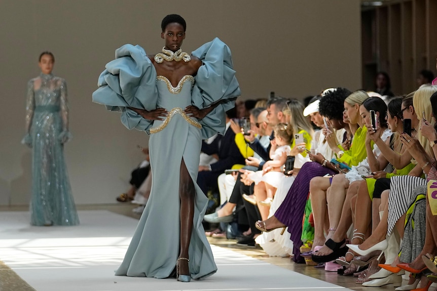 A model wearing a pastel blue dress with puffy sleeves. 