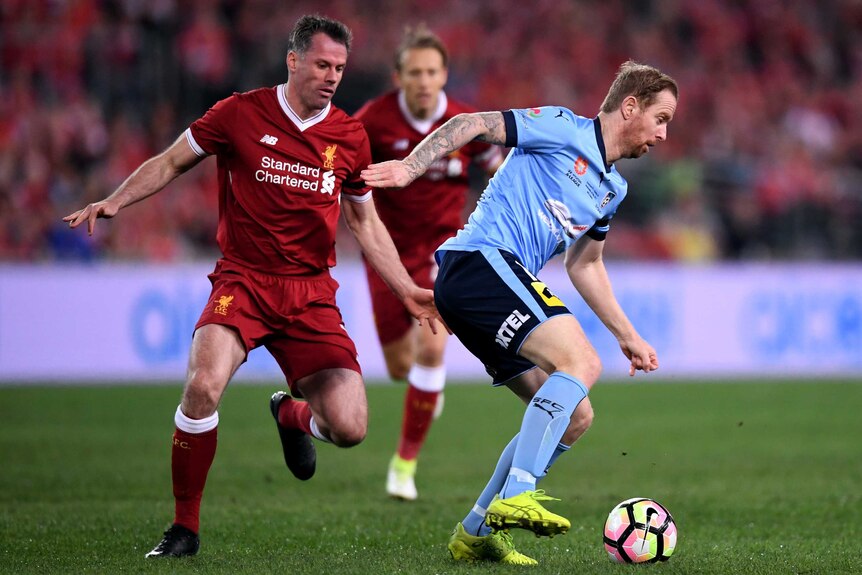 David Carney (right) of Sydney competes for the ball with Jamie Carragher (left) Liverpool.