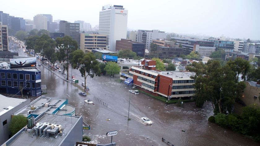 Cars drive down a flooded Melbourne street.