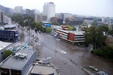 Cars drive down a flooded Melbourne street.