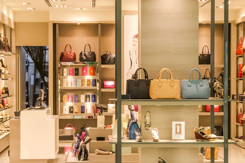 Bags and shoes are on display at a retail shopfront.