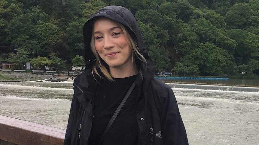 Australian woman Madison Lyden wears a black raincoat.