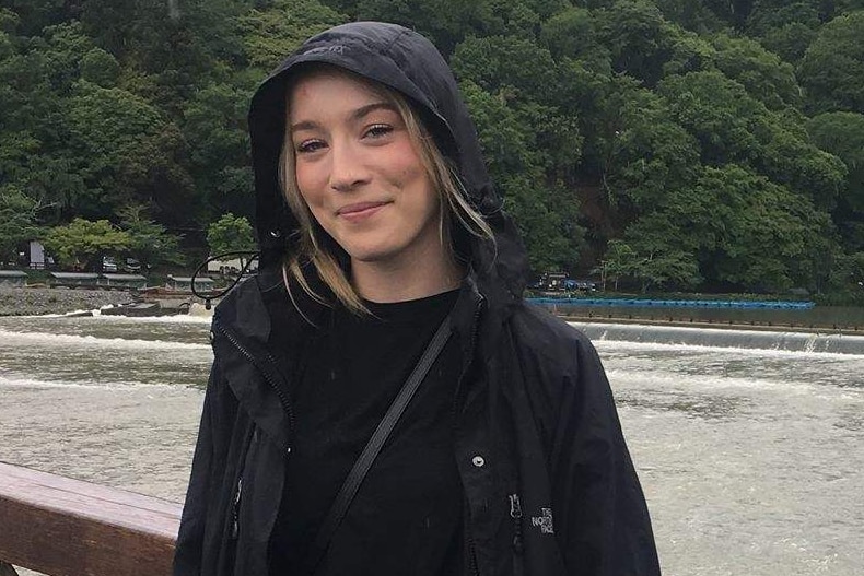 Australian woman Madison Lyden wears a black raincoat.