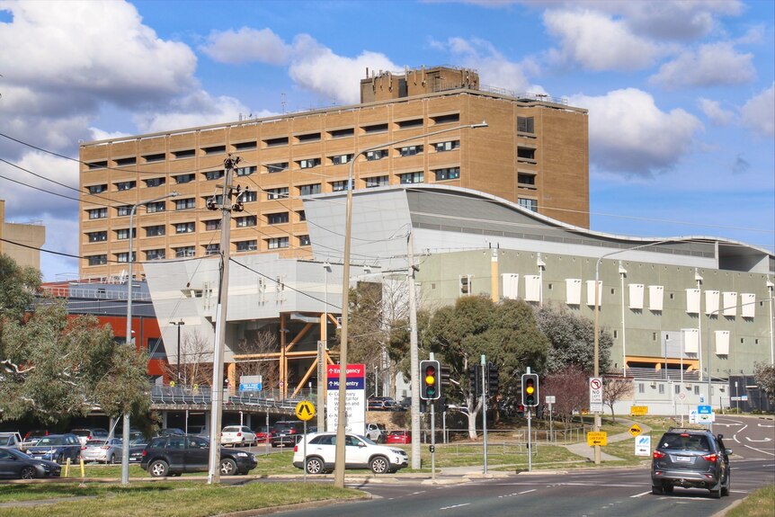 A hospital building seen from across a busy road.