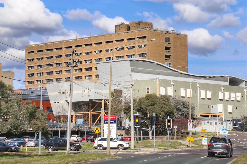 A hospital building seen from across a busy road.