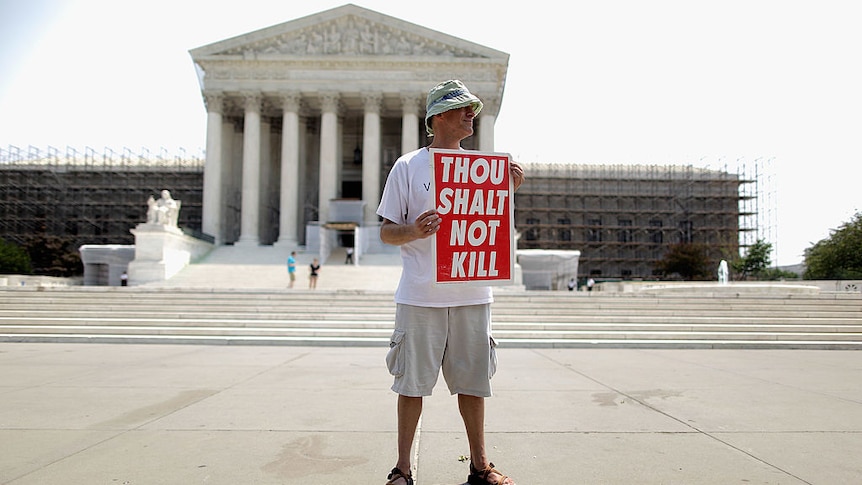 A man holds a sign against the death penalty