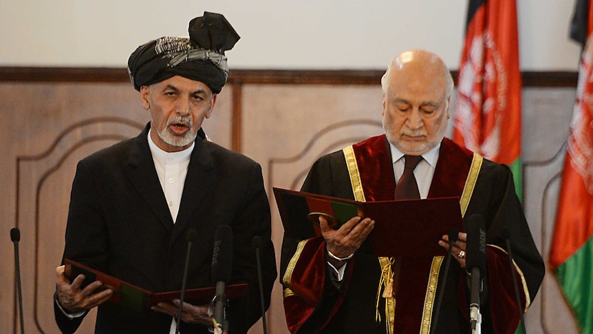 Ashraf Ghani (L) recites the oath next to Chief Justice Abdul Salam Azimi during the swearing in ceremony.