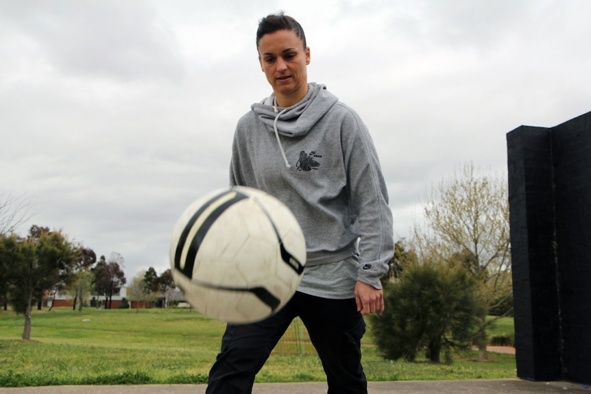 Former Matildas captain Melissa Barbieri kicks a football around outside.