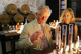 Prince Charles sniffing a beaker of rum inside Bundaberg Rum Distillery