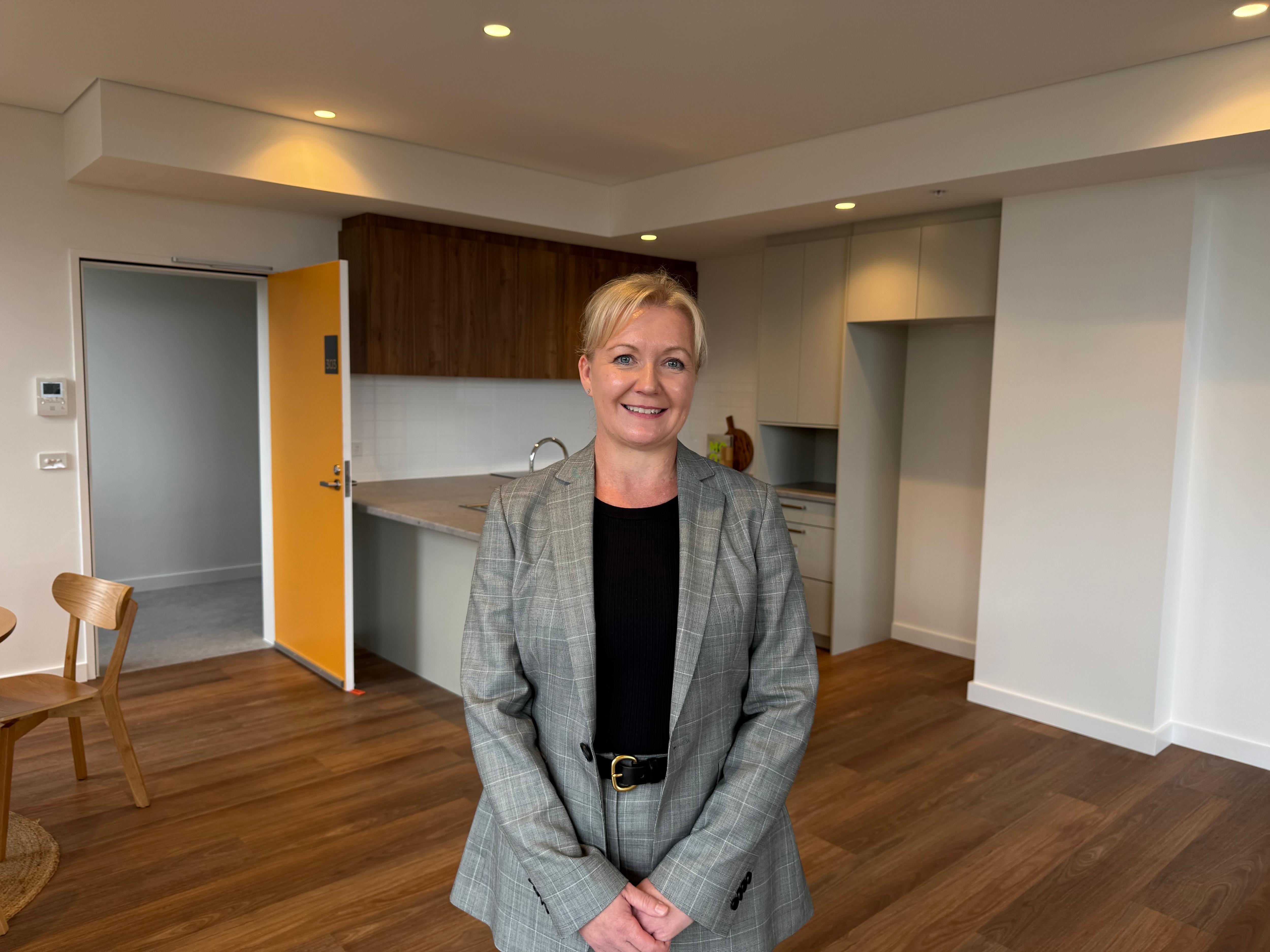 woman in suit in front of modern kitchen