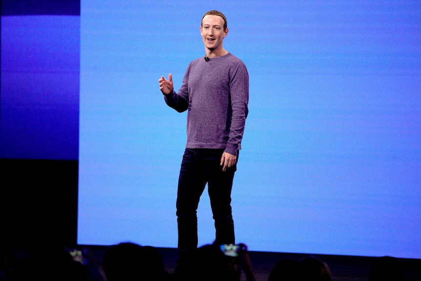 Mark Zuckerberg stands and gives a speech at a conference