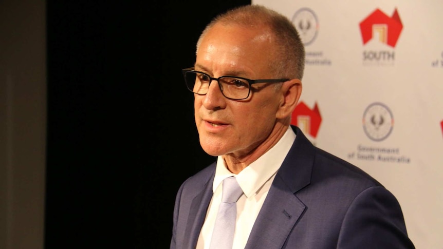 Premier Jay Weatherill in glasses at a news conference.