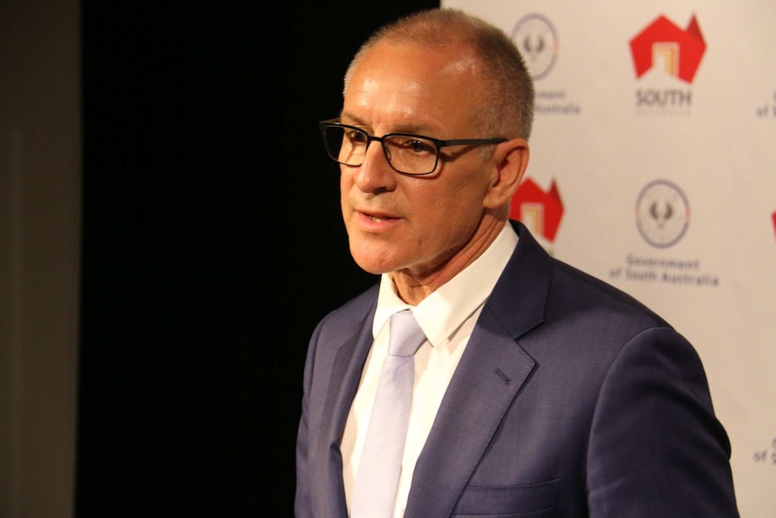 Premier Jay Weatherill in glasses at a news conference.