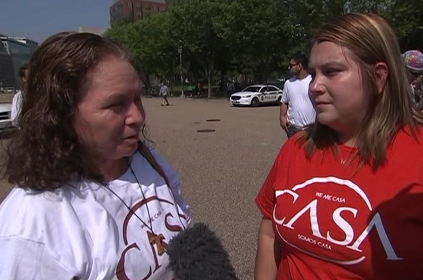 Two Mexican women speak into a microphone at a street protest.