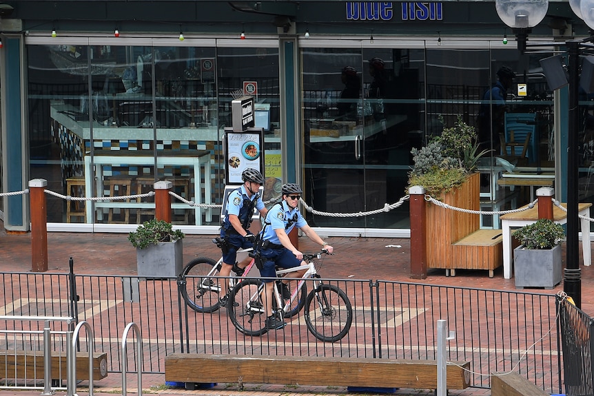 nsw police on bikes patrol the Darling Harbour precinct during the covid-19 lockdown in 2020