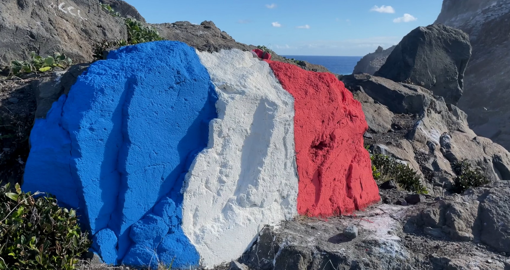 A rock painting in the colours of the French flag. 
