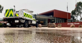 A CFA truck is parked in the Bairnsdale Incident Control Centre, as water runs along the driveway from rain.