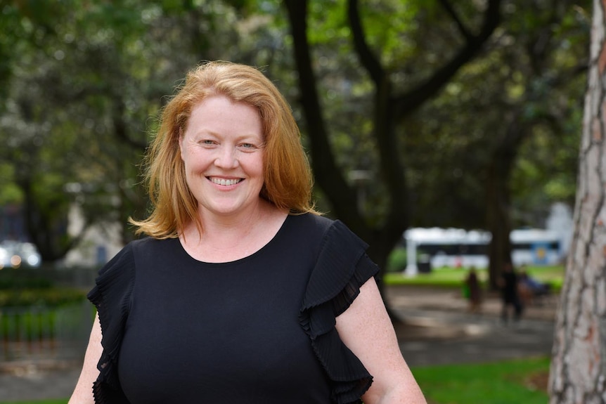 A woman smiling in a park